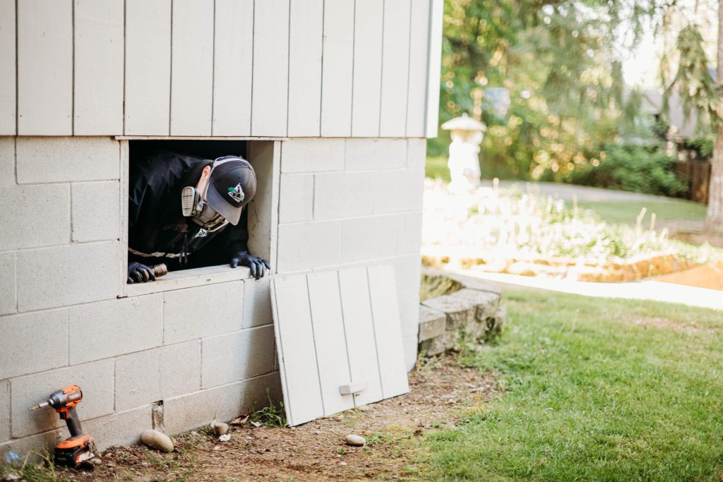 Collin County pest control technician inspecting a crawlspace.